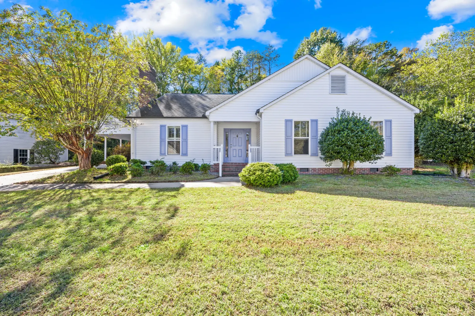 Front of 477 Birchwood Trail NE: white ranch home with lavender shutters and a crepe myrtle