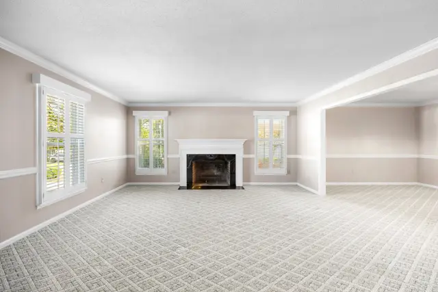 Family room with wood-burning fireplace and plantation shutters