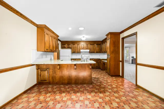 Kitchen with granite counters, breakfast bar and wood cabinetry